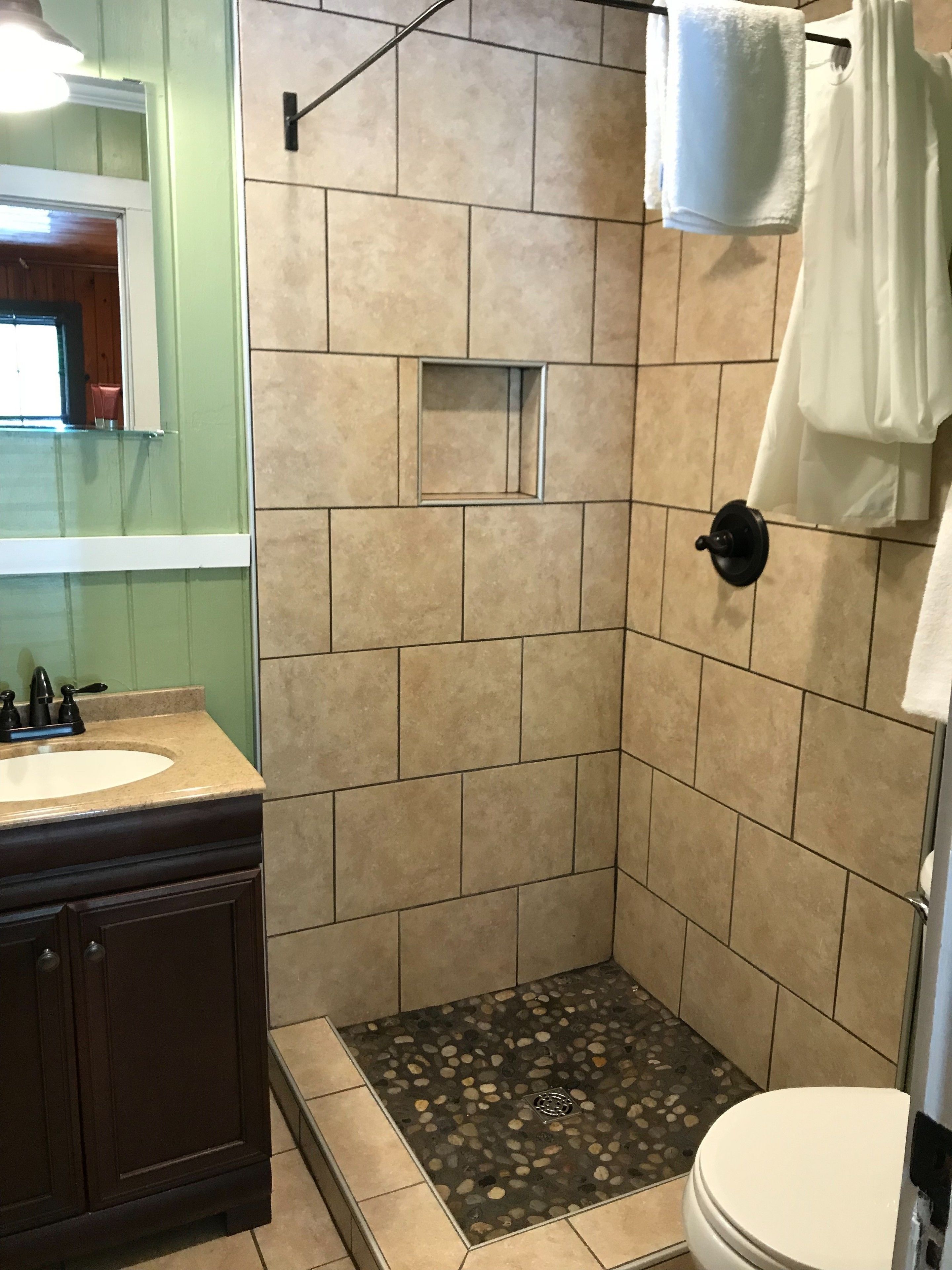 A bathroom with a shower, toilet, and sink.