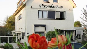 A two-story building with a sign reading "Pirombo B&B". - Pirombo Bed & Breakfast (Noordwijk)