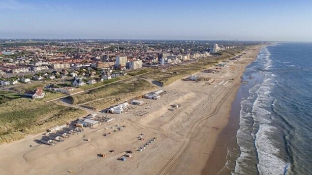 An aerial view of a coastal city with a beach, buildings, and a clear sky. - Pirombo Bed & Breakfast (Noordwijk)