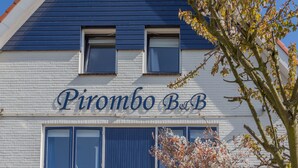A building with a sign reading "Pirombo B&B" and a tree in the foreground. - Pirombo Bed & Breakfast (Noordwijk)