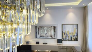 A modern living room with a large chandelier, a sofa, a coffee table, and artwork on the walls.