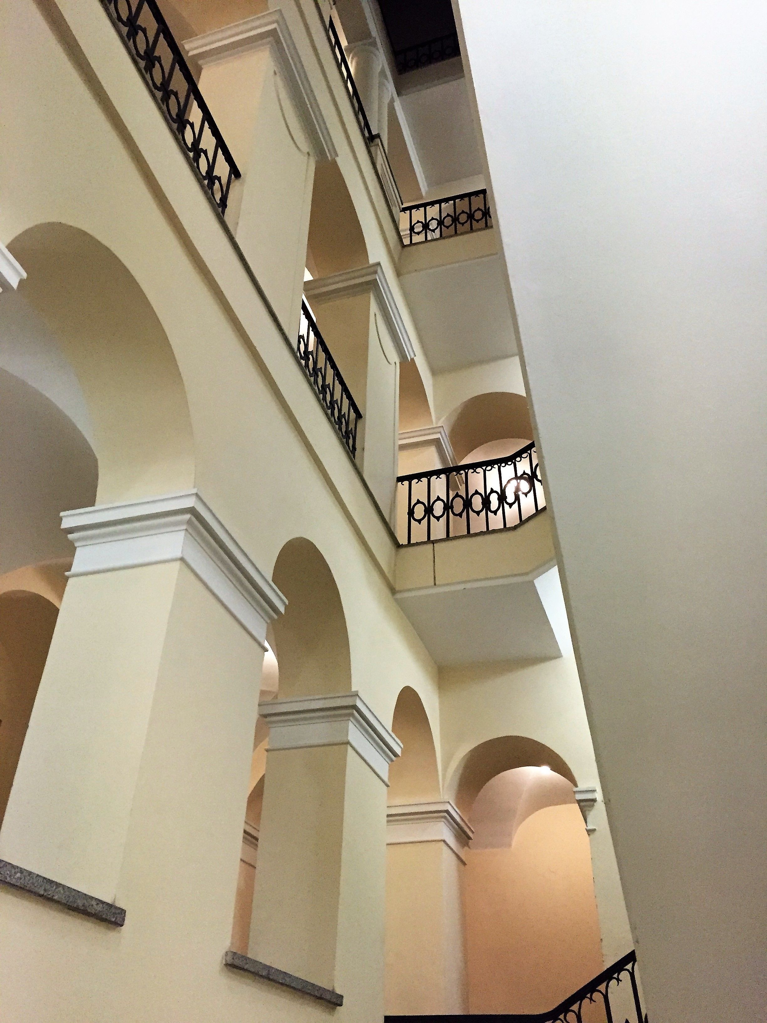 A multi-level interior with arched balconies and a staircase.