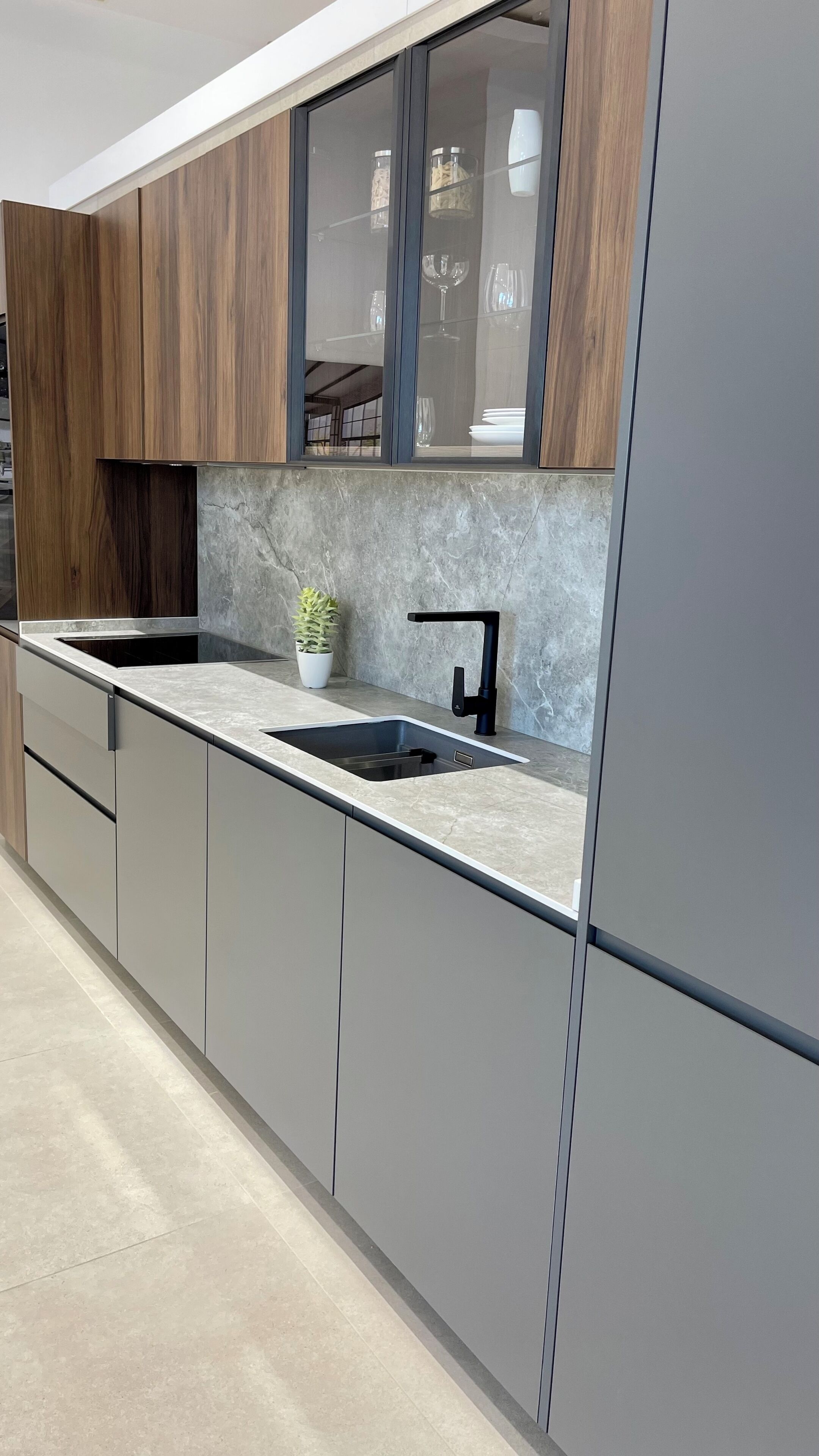 Una cocina moderna con un lavaplatos integrado, una planta en maceta y una ventana sobre la encimera.