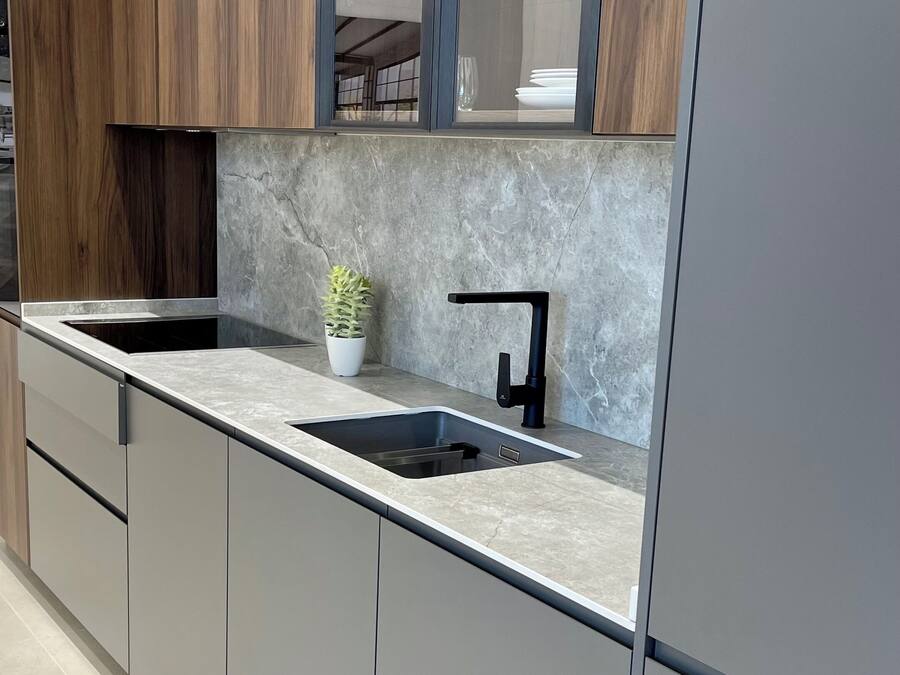 Una cocina moderna con un lavaplatos integrado, una planta en maceta y una ventana sobre la encimera.