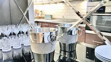 Uma cozinha com eletrodomésticos de aço inoxidável, bancada com copos e micro-ondas.