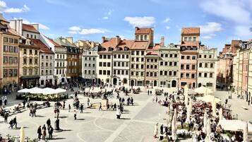 A bustling square with historic buildings, outdoor cafes, and a cobblestone pavement.