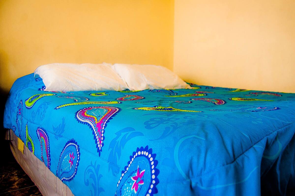 A bed with a colorful bedspread and pillows.