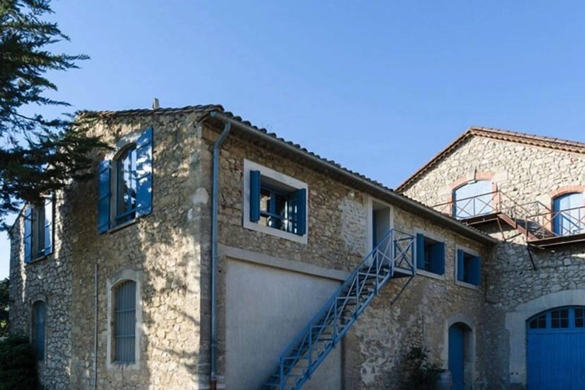 Un bâtiment en pierre avec un escalier bleu menant à un garage.