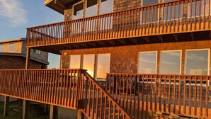 A two-story wooden house with a balcony and a staircase leading to the upper level. - Deals on Summer Sunsets! Aug 24-28, Aug 31-Sept 4. Spacious Oceanfront w/wifi (Grayland)