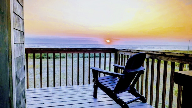 A wooden deck with a single Adirondack chair facing a sunset over the ocean. - Deals on Summer Sunsets! Aug 24-28, Aug 31-Sept 4. Spacious Oceanfront w/wifi (Grayland)