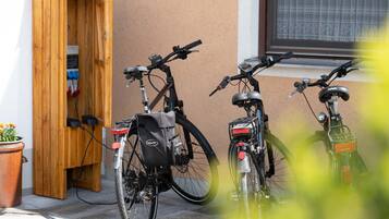 Dos bicicletas estacionadas frente a un edificio con puerta de madera y ventana.