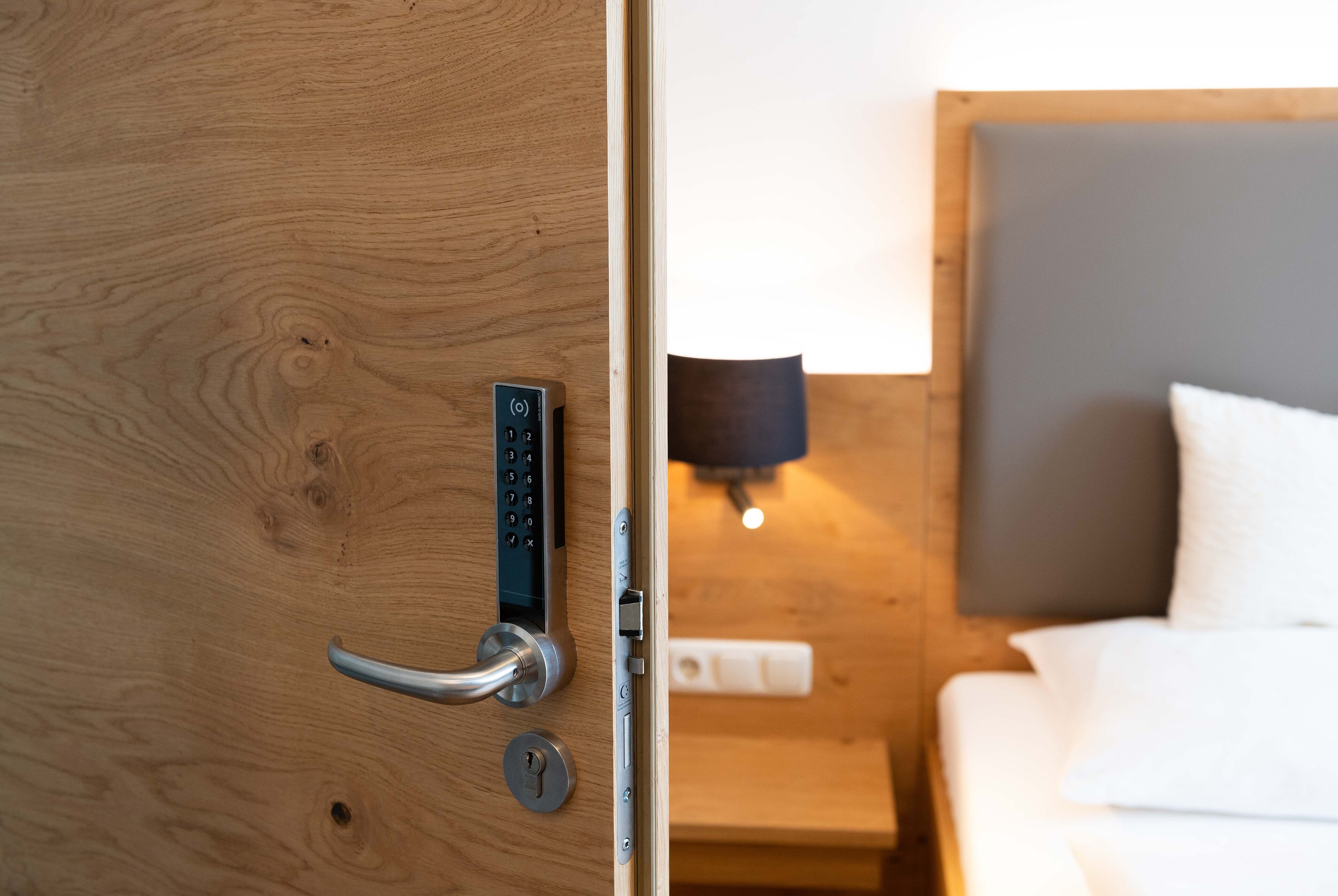 A wooden door with a modern electronic lock and a keyhole.