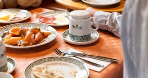 A dining table with plates of food, a teapot, and cutlery. - Hotel Gasthof Rosenwirt (Au in der Hallertau)