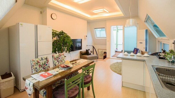 A compact kitchen with a dining area, a small living space, and a view of the outside. - Stay Young (Seoul)