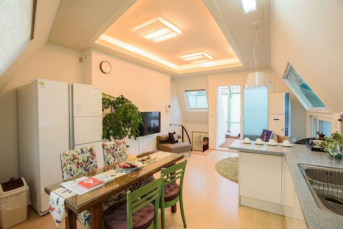 A compact kitchen with a dining area, a small living space, and a view of the outside.