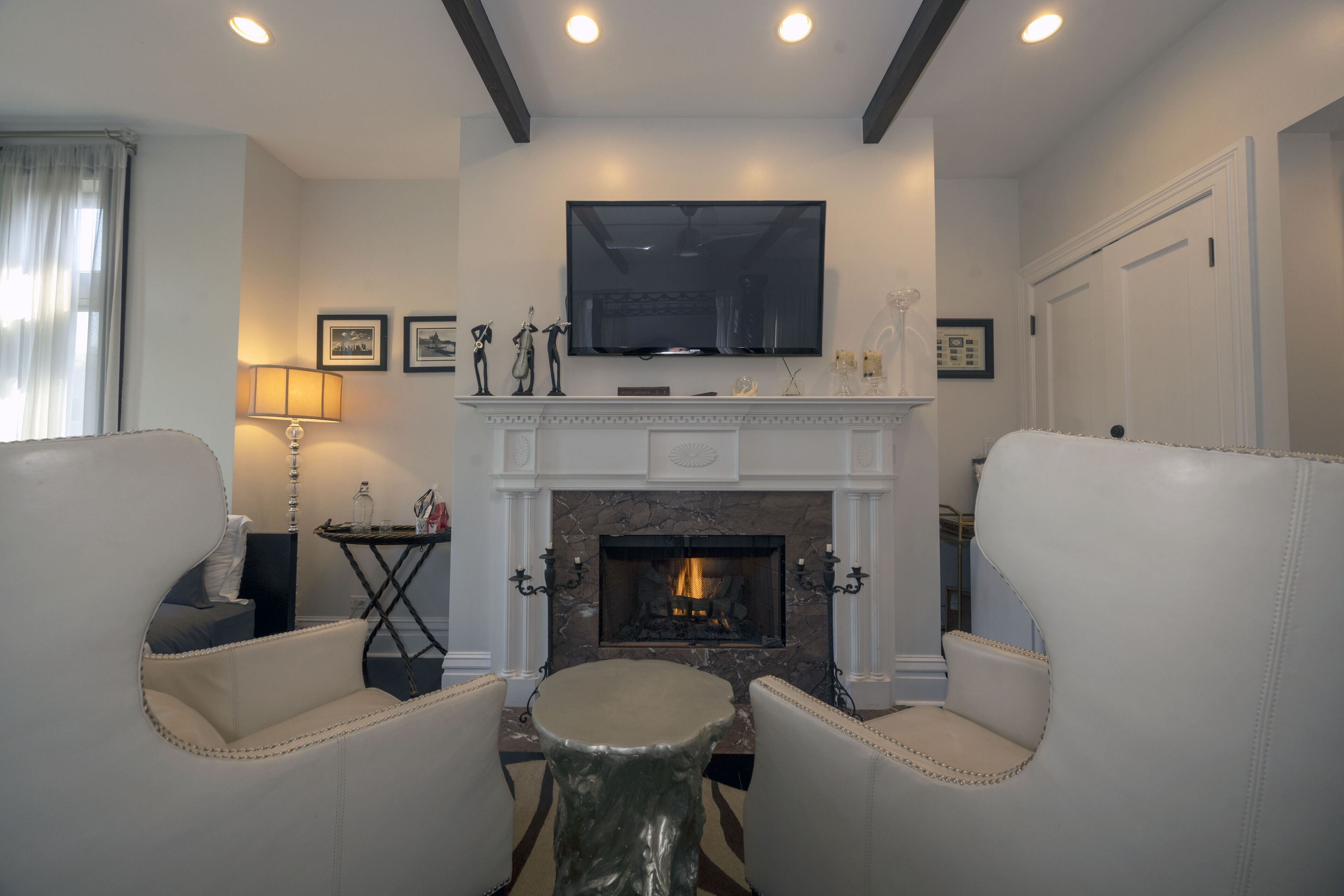 Una sala de estar con chimenea, un televisor de pantalla plana y dos sillones de cuero.