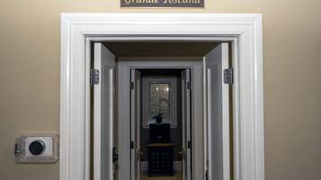 A hallway with a sign reading "Grande Toscana" above a white door.