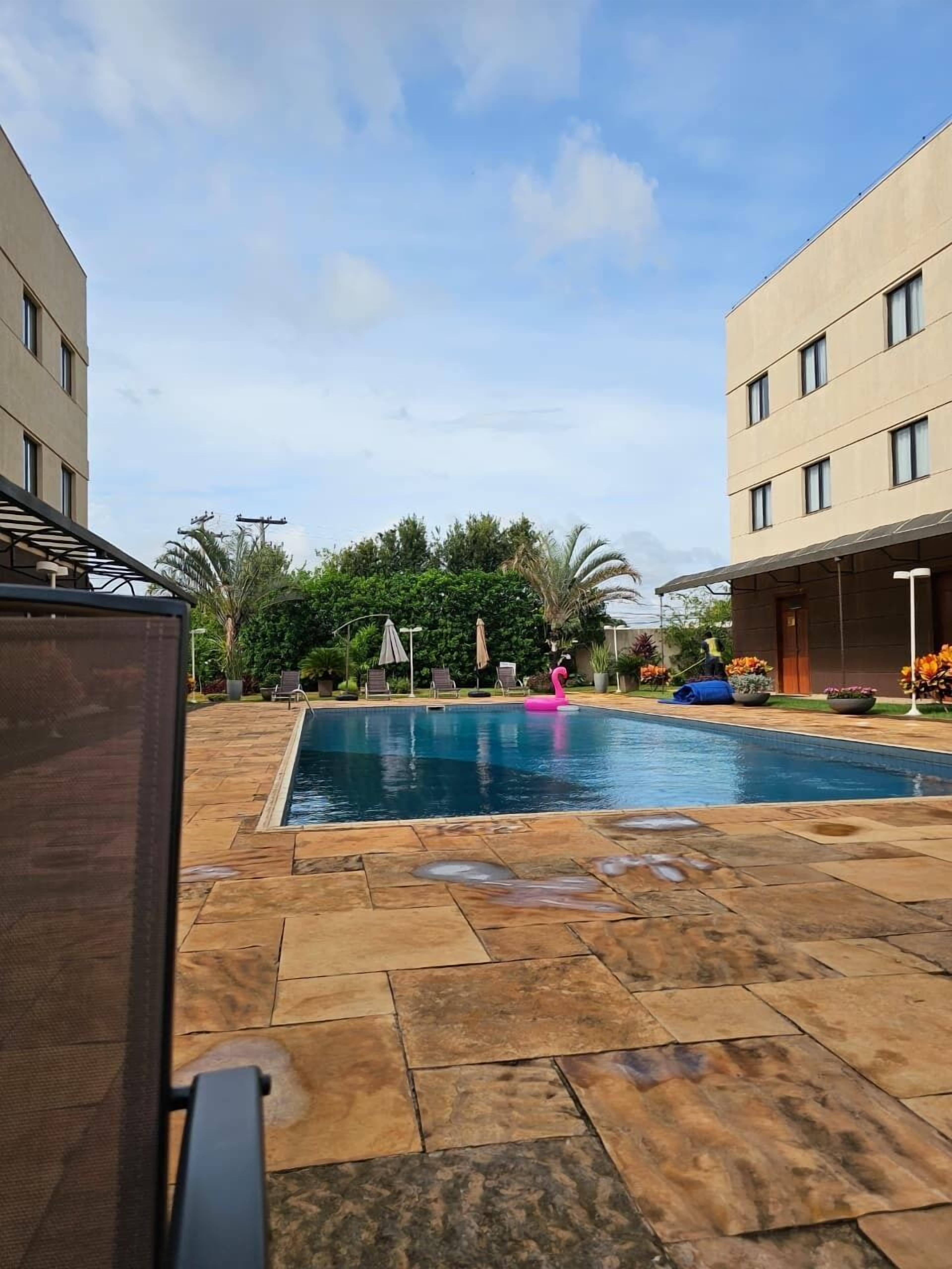 Una piscina al aire libre, sillones reclinables de piscina