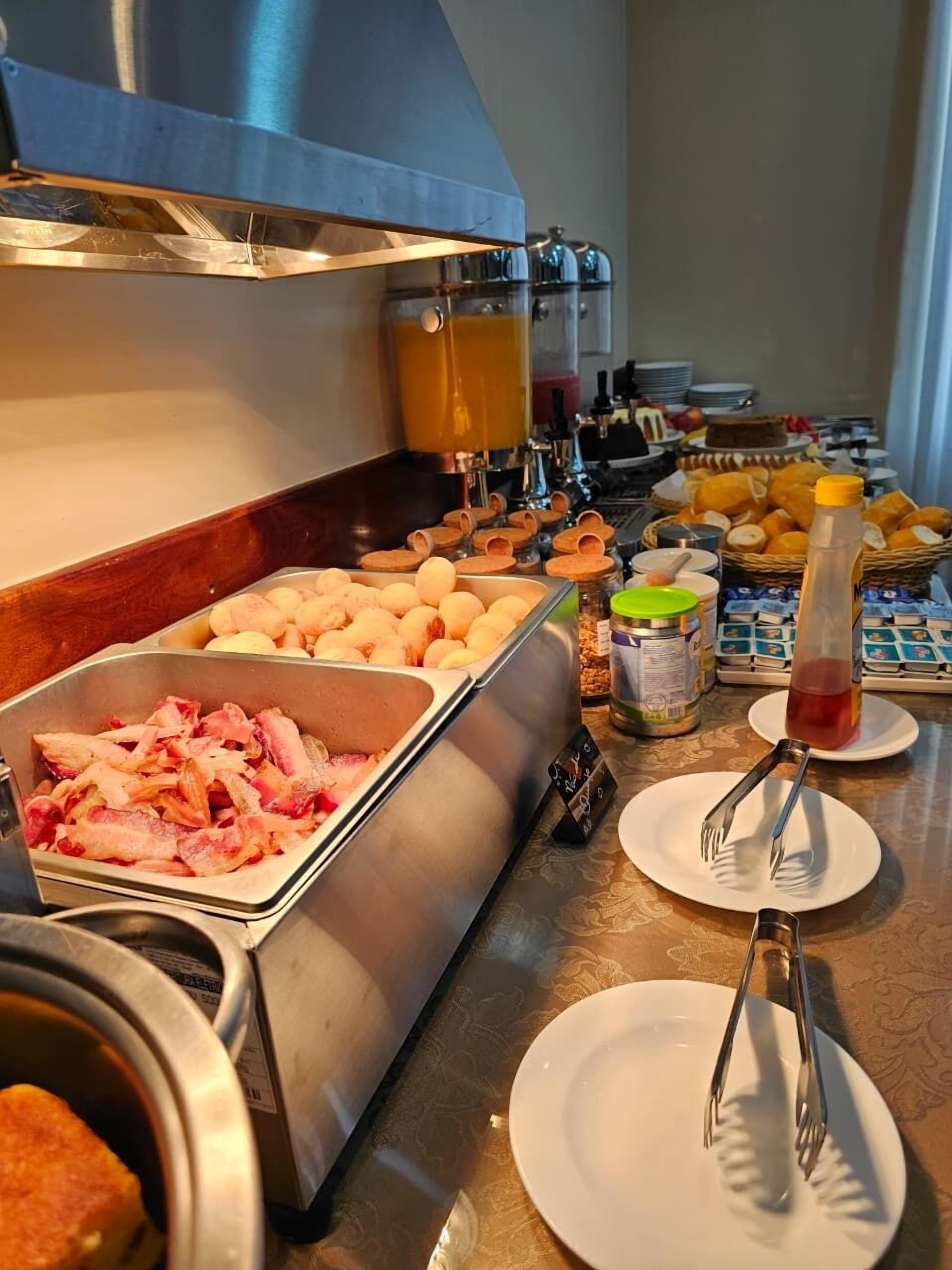 Un bufé con diferentes opciones de comida, incluyendo carne, huevos y frutas.