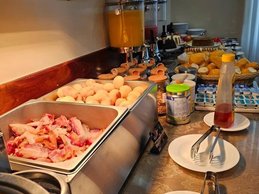 Un bufé con diferentes opciones de comida, incluyendo carne, huevos y frutas.