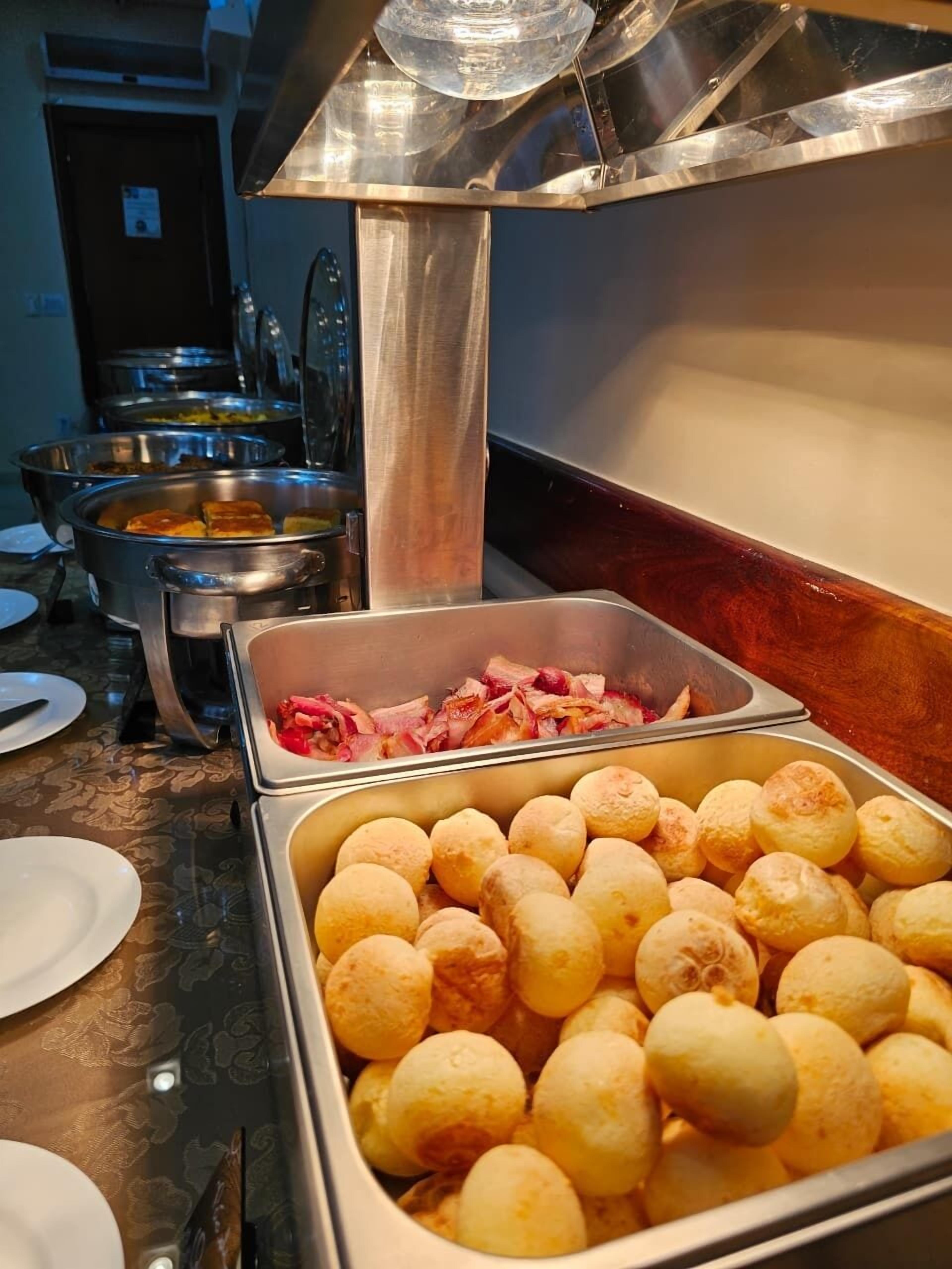 Un bufé con diversos alimentos, incluyendo panes y carnes cocinadas.