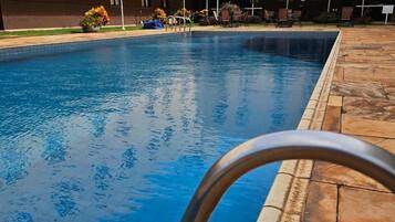 Alberca al aire libre y camastros