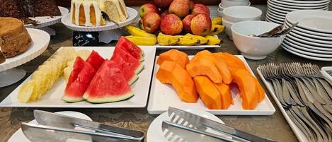 A buffet with various fruits and desserts.