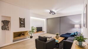 Una sala de estar moderna con chimenea, un sofá, una mesa de centro y un televisor.