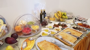 Ein reichhaltiges Buffet mit verschiedenen Speisen, darunter Obst, Käse und Gebäck.