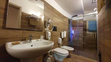 Ein modernes Badezimmer mit einem großen Waschbecken, zwei Toiletten, einer Duschkabine aus Glas und Holzvertäfelung.