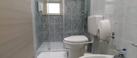 A bathroom with a toilet, bidet, and sink.