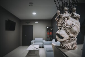 Un interior moderno con una escultura decorativa en una mesa, un sofá y una mesa de centro al frente.