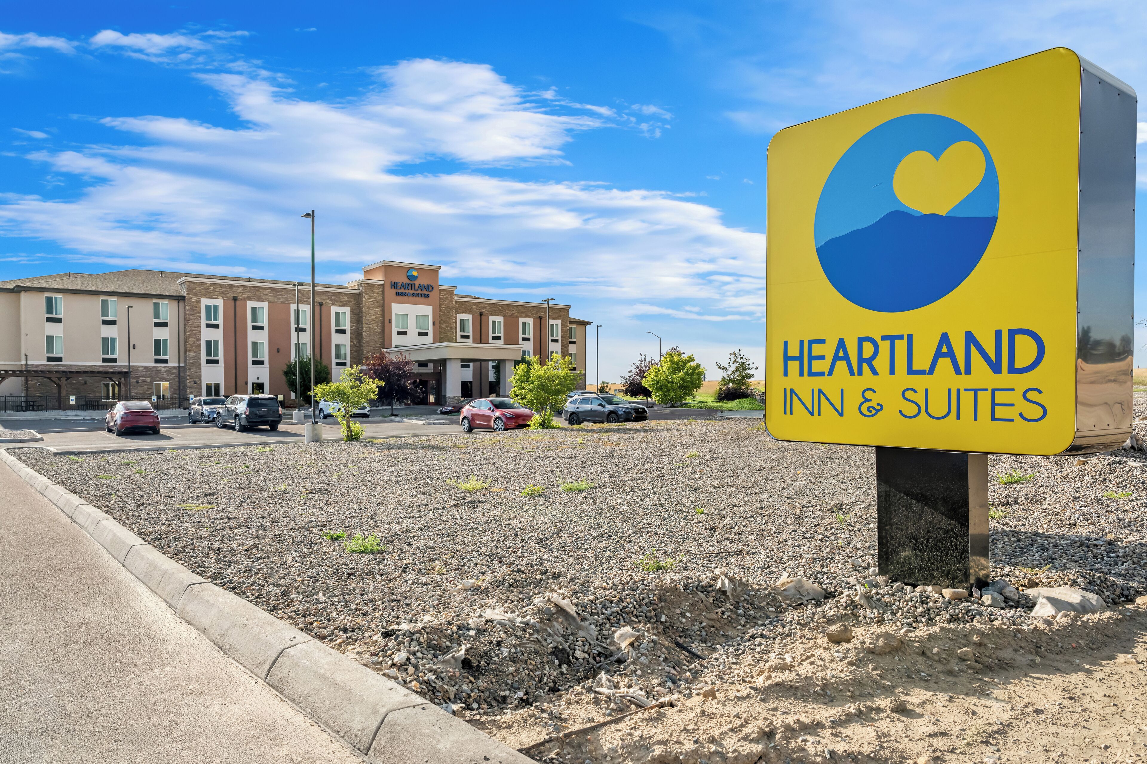 A Heartland Inn & Suites sign with a clear view of the building in the background.