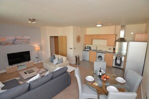 Um apartamento moderno com sala de estar, sala de jantar e cozinha.