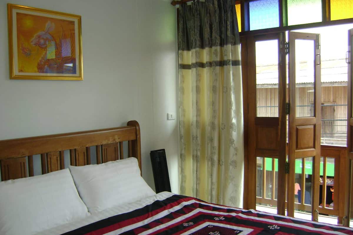 Ein Schlafzimmer mit einem Bett, einem Bild an der Wand und Blick durch eine Tür.