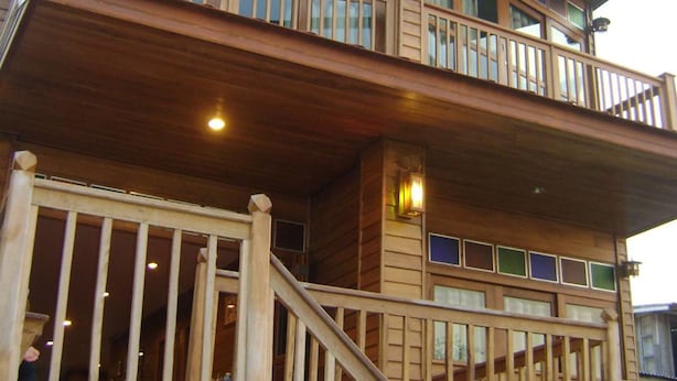 Un immeuble en bois à plusieurs étages, doté d’un balcon et d’un escalier.