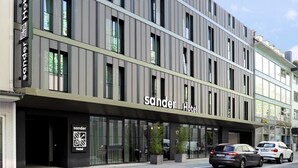 Un hôtel moderne, avec une façade sobre, de grandes fenêtres et une entrée bien visible.