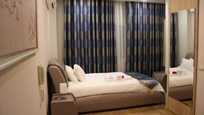 Une chambre d’hôtel avec un lit, une table de chevet et un miroir.