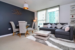 Apartamento urbano, 1 cama King e sofá-cama, vista para a cidade | Sala de estar | TV de tela plana 50 polegadas com canais digitais, TV, Netflix