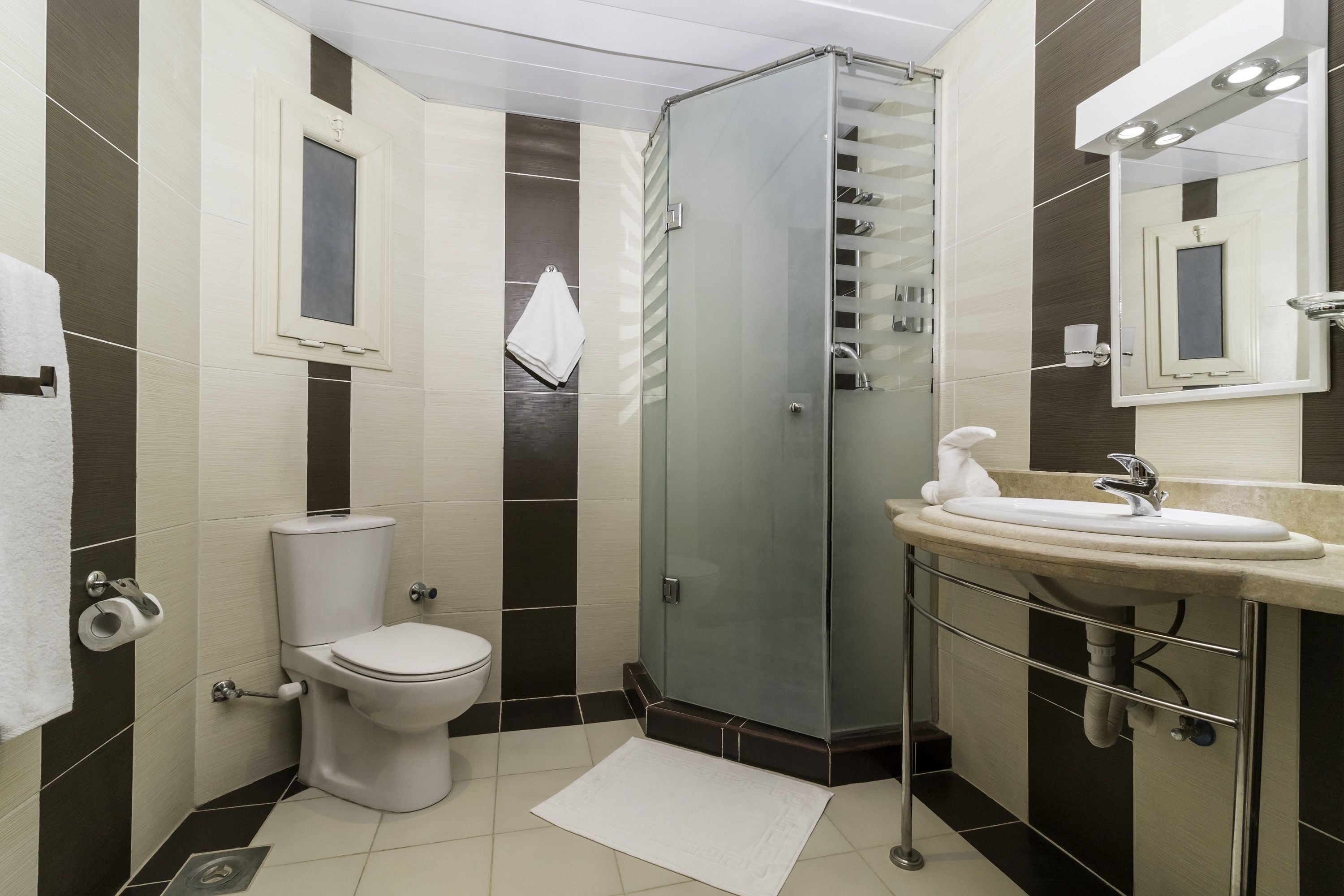 Een moderne badkamer met toilet, douche en wastafel.