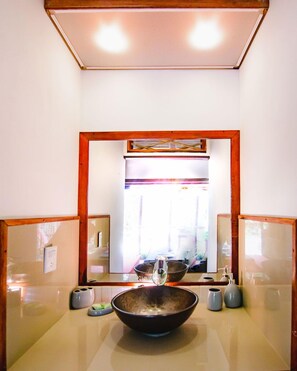 A bathroom with a large mirror, a sink with a bowl, and a window with natural light. - Uva Blue Villas (Cahuita)