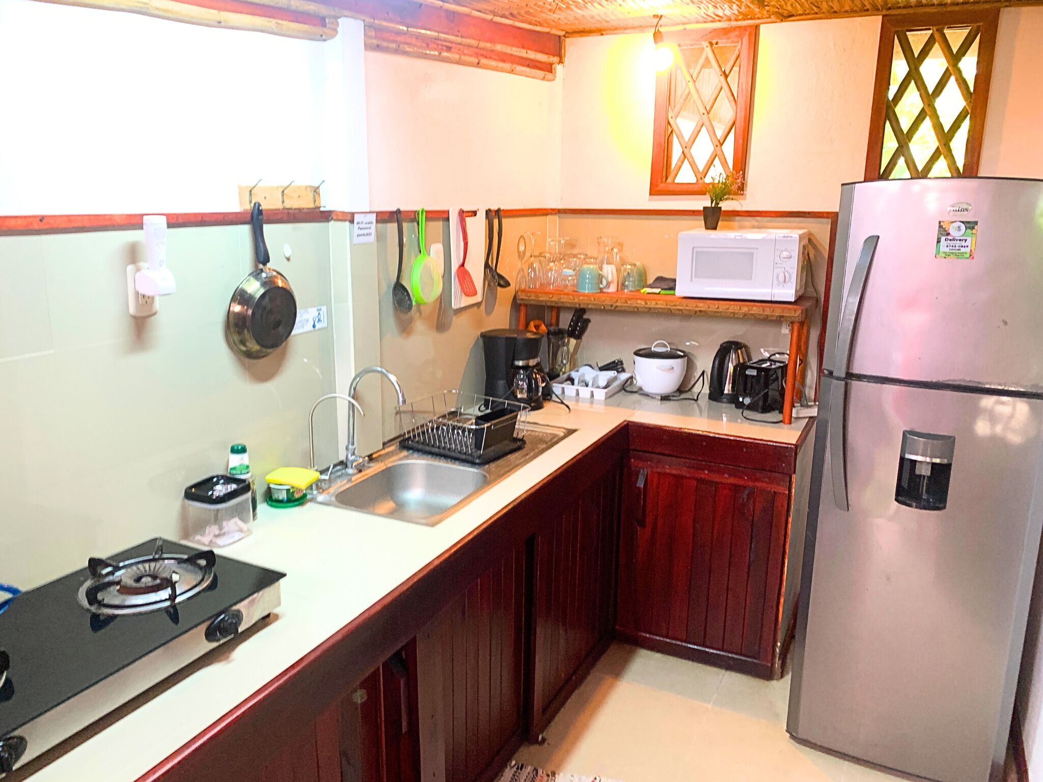 Una cucina compatta con piano cottura a gas, lavello, forno a microonde e frigorifero.