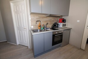 Apartamento conforto, 1 quarto | Cozinha americana privada | Geladeira, cooktop, chaleira elétrica