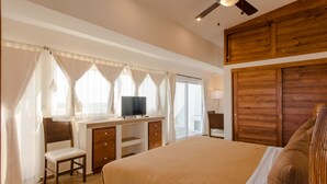 Un dormitorio con cama, escritorio, silla, televisor y armario.