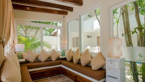 Una sala de estar moderna con un banco empotrado, ventanas amplias y un dispensador de agua.