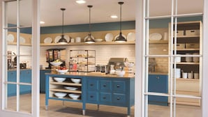 A modern kitchen with blue cabinetry, white countertops, and pendant lighting. - Country Inn & Suites by Radisson Lawrence (Lawrence)
