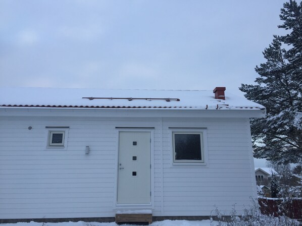 A white house with a white door, two windows, and a chimney. - Great Stay Guest House Sandviken (Sandviken)