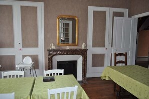 A dining room with a fireplace, two white doors, and a mirror above it. - La Villa Saint Pierre (Epernay)