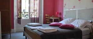 A bedroom with a bed, pillows, a bedside table, and a chair. - La Villa Saint Pierre (Epernay)