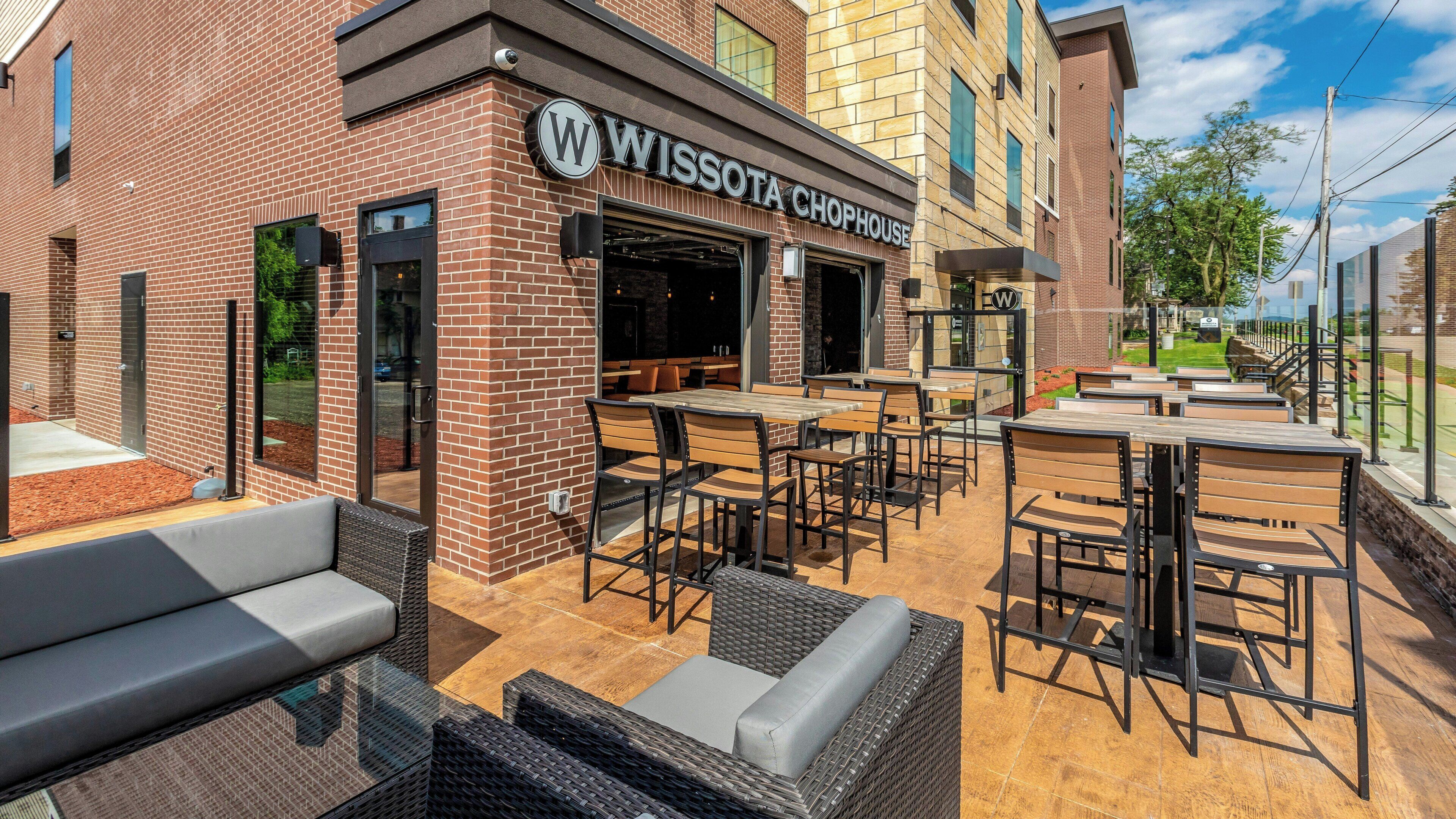Un edificio in mattoni con posti a sedere all'aperto e un cartello con la scritta 'WISSOTA CHOPHOUSE'.